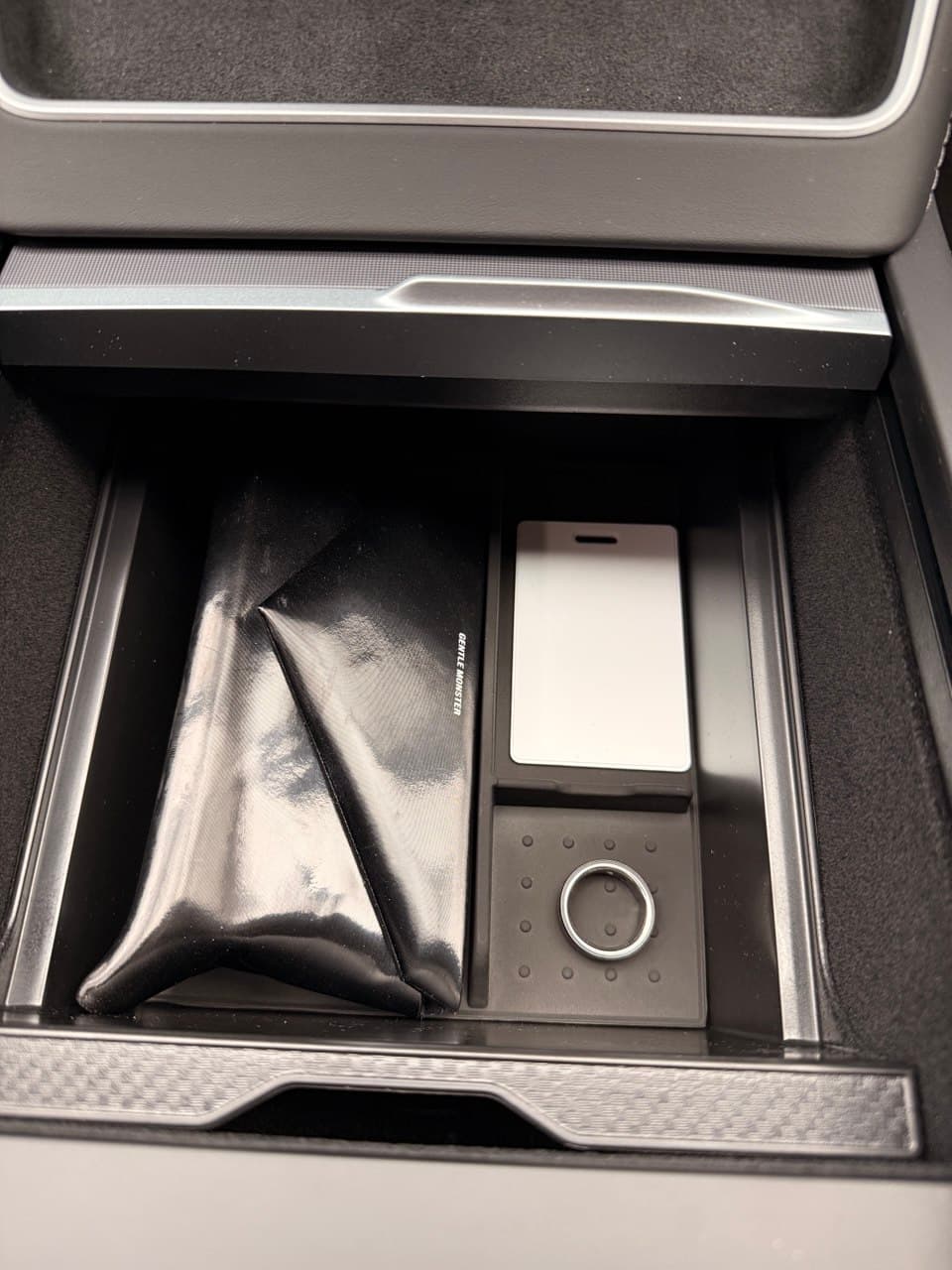 Console storage box with sunglasses case, ring, and phone — real daily use