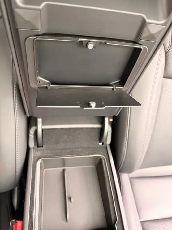 Armrest storage box opened showing divider and felt lining inside