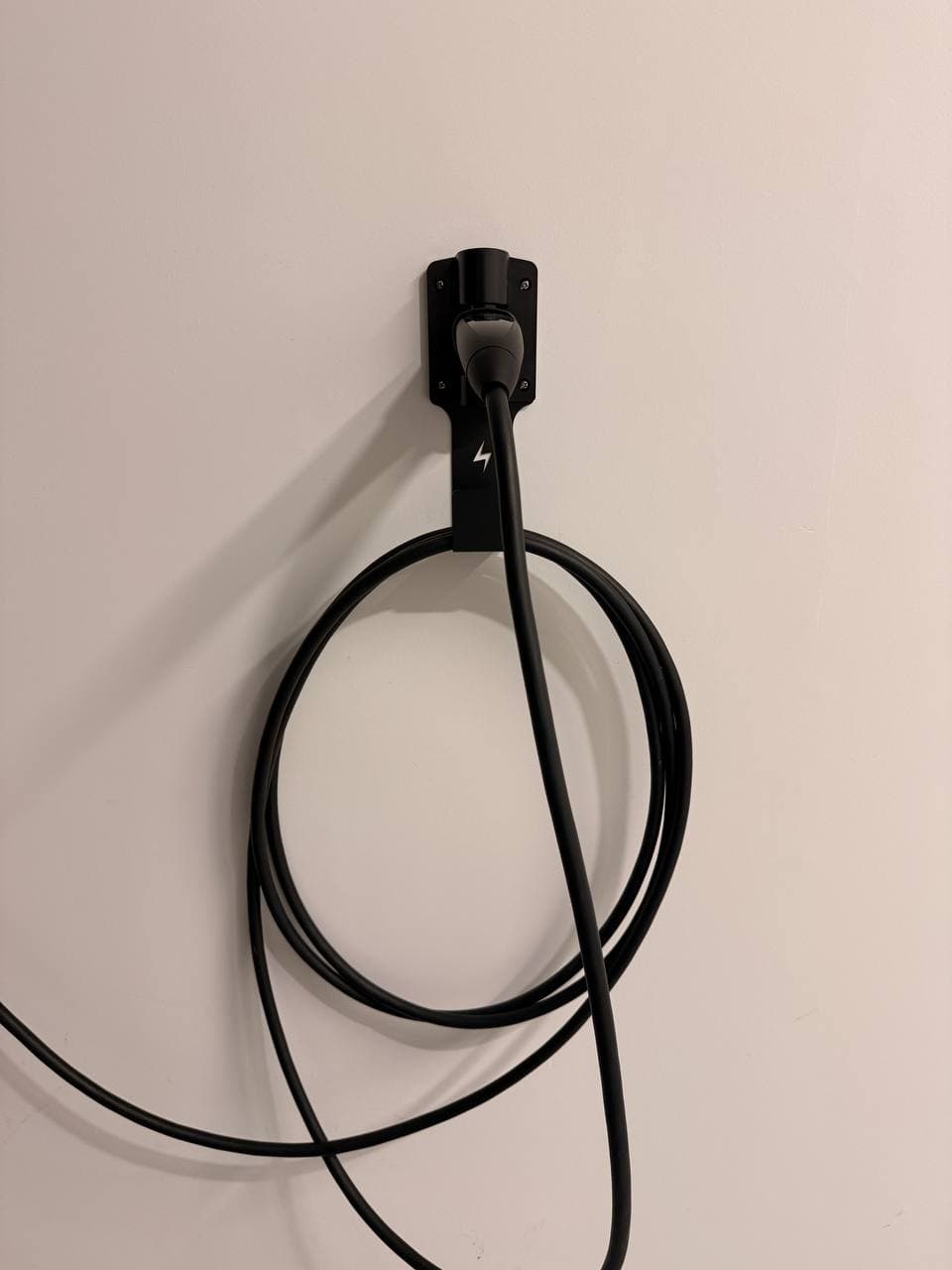 Tesla charging cable coiled on FOCSPROD wall-mounted J-hook
