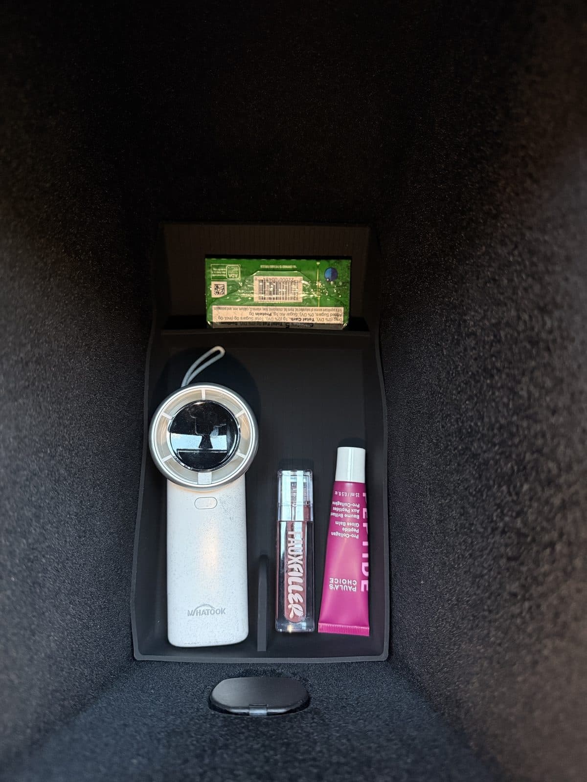 SUMK bottom liner in use under daily items in a Model Y Juniper console bin