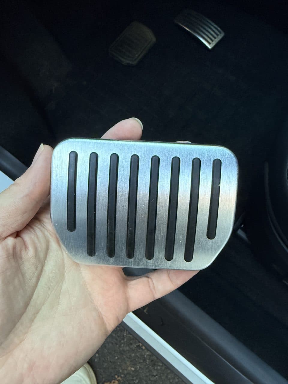 Close-up of the TOPFIT aluminum brake pedal cover held in hand
